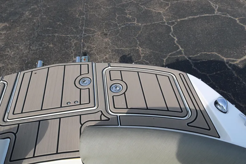 Slide: The Image of 2016 Bayliner 215 Deck Boat swim platform with textured surface and storage compartments. - 27