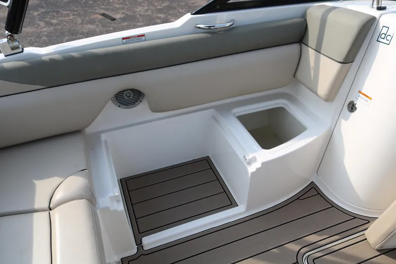 Slide: The Image of 2016 Bayliner 215 Deck Boat interior with seating and storage compartments. - 36