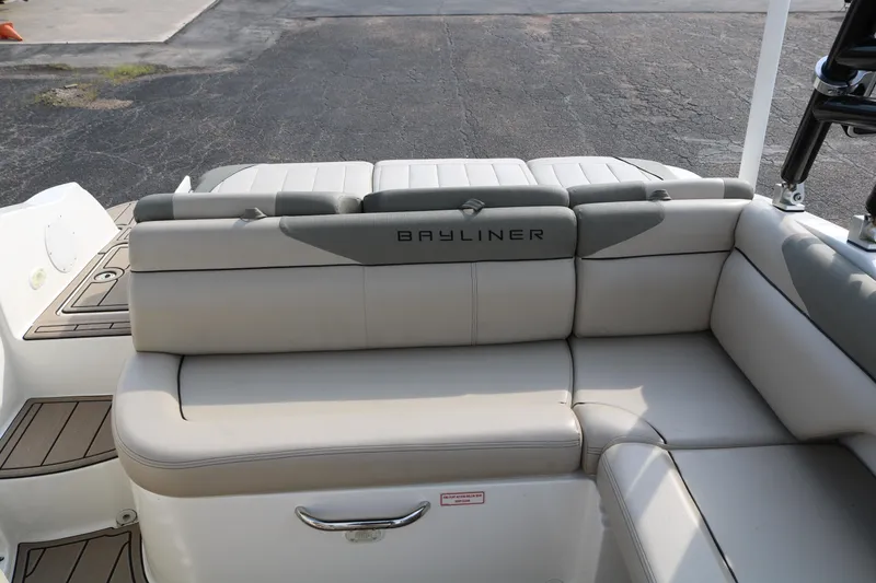 Slide: The Image of 2016 Bayliner 215 Deck Boat with beige seating and Bayliner logo. - 37