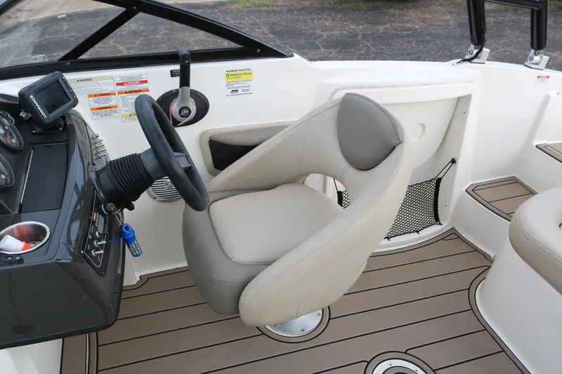 Slide: The Image of 2016 Bayliner 215 Deck Boat interior with steering wheel and captain's seat. - 43