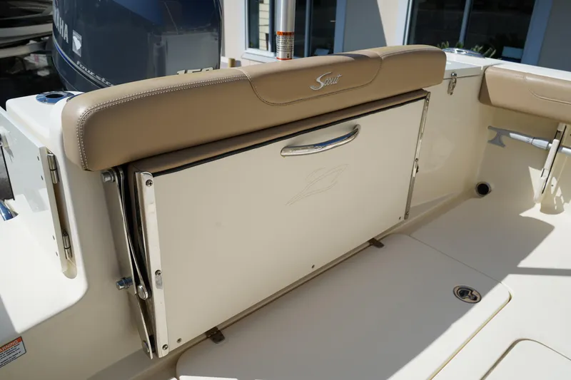 Slide: The Image of 2022 Scout 215 XSF boat interior with beige seating and storage compartment. - 10