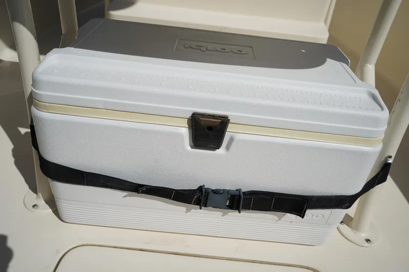 Slide: The Image of White cooler secured on 2022 Scout 215 XSF boat with black strap. - 15