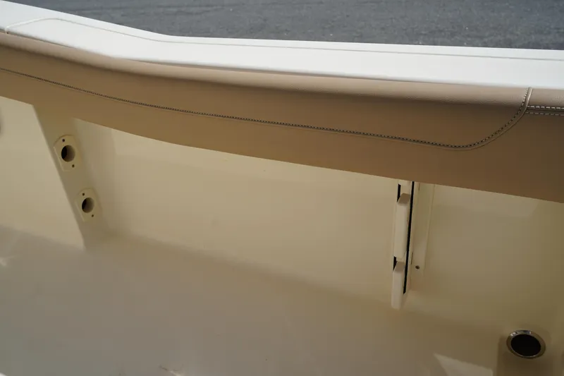 Slide: The Image of 2022 Scout 215 XSF boat interior detail with beige upholstery and storage compartment. - 20