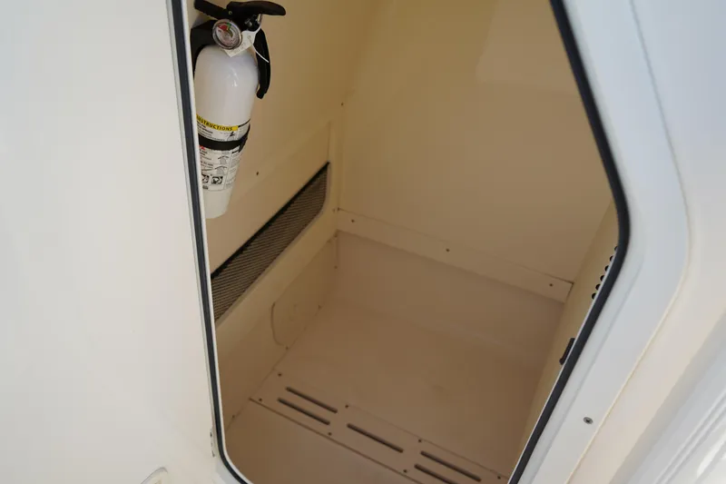 Slide: The Image of 2022 Scout 215 XSF boat storage compartment with fire extinguisher. - 31