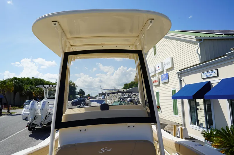 Slide: The Image of 2022 Scout 215 XSF boat at dealership, showcasing T-top and seating. - 32