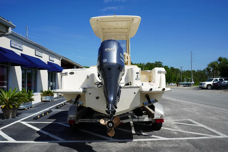 Slide: The Image of 2022 Scout 215 XSF boat with outboard motor in a parking lot. - 7