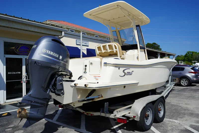 Slide: The Image of 2022 Scout 215 XSF boat on trailer with Yamaha outboard motor, parked outdoors. - 8