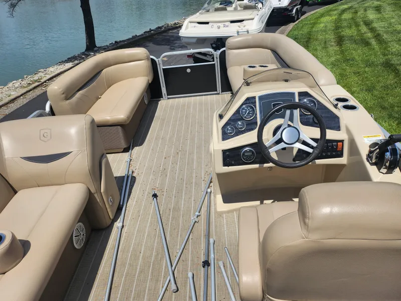 Slide: The Image of 2018 Sweetwater 2086 C pontoon boat interior with beige seating and steering console. - 18