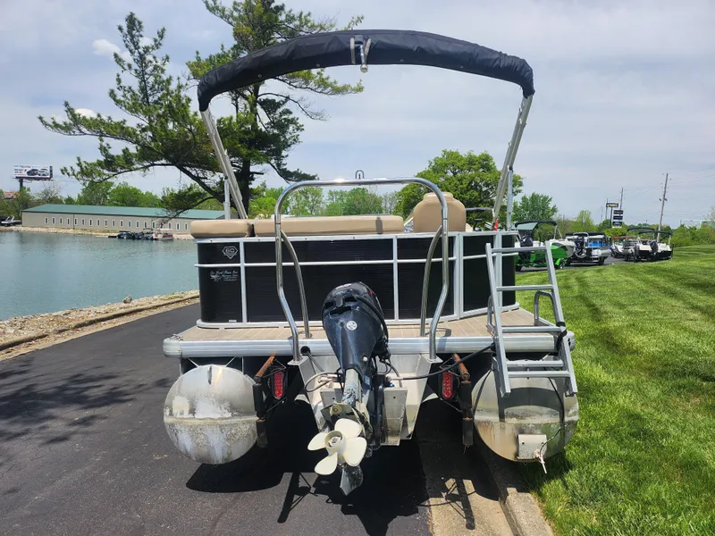 Slide: The Image of 2018 Sweetwater 2086 C pontoon boat parked by a lakeside road. - 2
