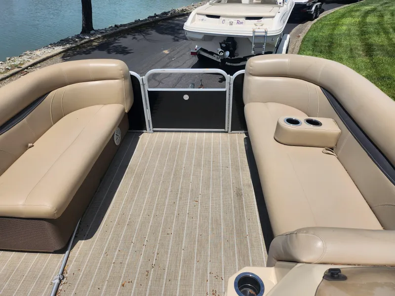 Slide: The Image of 2018 Sweetwater 2086 C pontoon boat interior with beige seating and cup holders. - 22