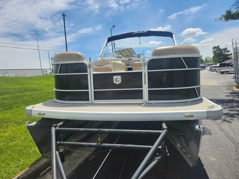 Slide: The Image of 2018 Sweetwater 2086 C pontoon boat on trailer, parked outdoors under blue sky. - 6