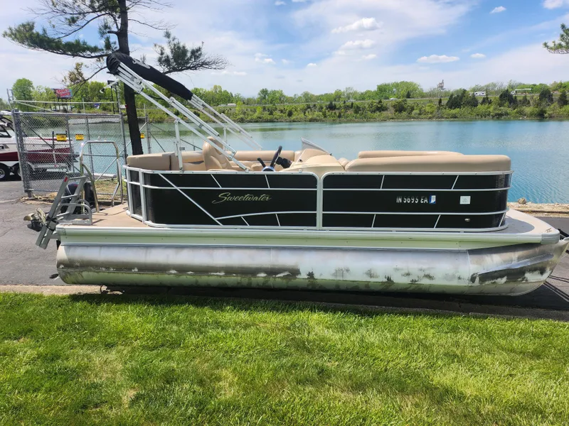 Slide: The Image of 2018 Sweetwater 2086 C pontoon boat parked by a scenic lake. - 8