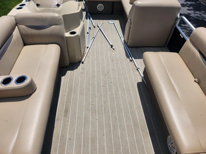 Slide: The Image of 2018 Sweetwater 2086 C pontoon boat interior with beige seating and cup holders. - 9
