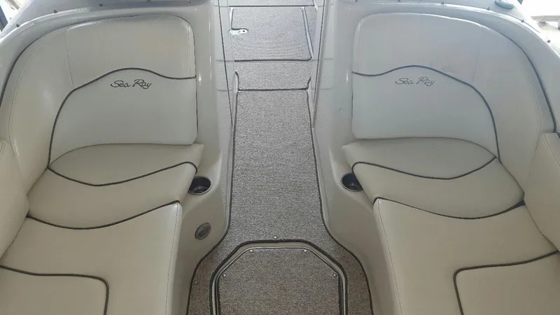 Slide: The Image of 2008 Sea Ray 240 Sundeck interior with white seating and carpeted flooring. - 12