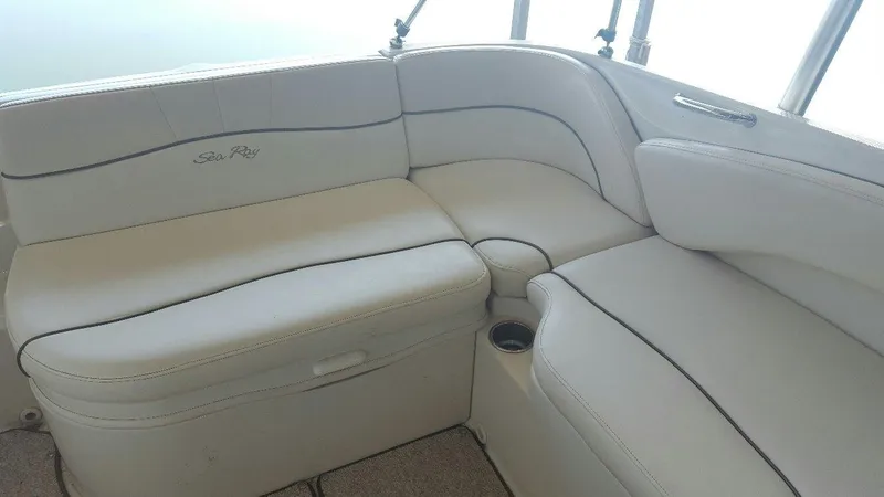 Slide: The Image of 2008 Sea Ray 240 Sundeck interior with white cushioned seating. - 14