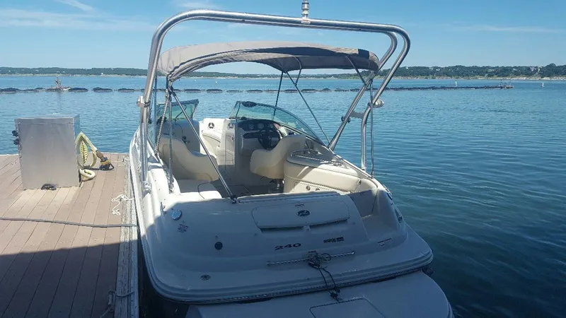 Slide: The Image of 2008 Sea Ray 240 Sundeck boat docked by a serene lake under clear skies. - 4