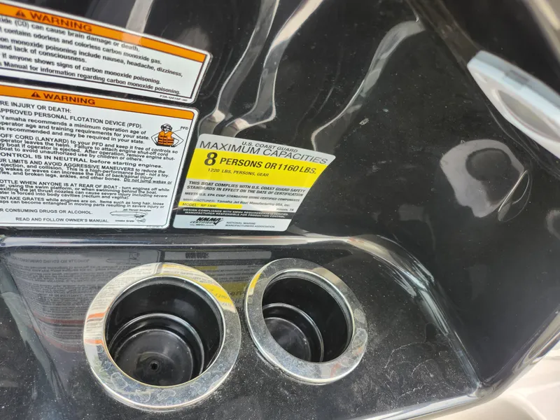 Slide: The Image of 2017 Yamaha SX195 boat capacity label and cup holders. - 14