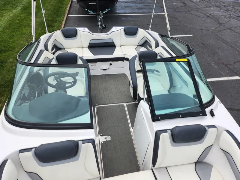 Slide: The Image of 2017 Yamaha Boats SX195 interior with seating and steering wheel, parked on pavement. - 20