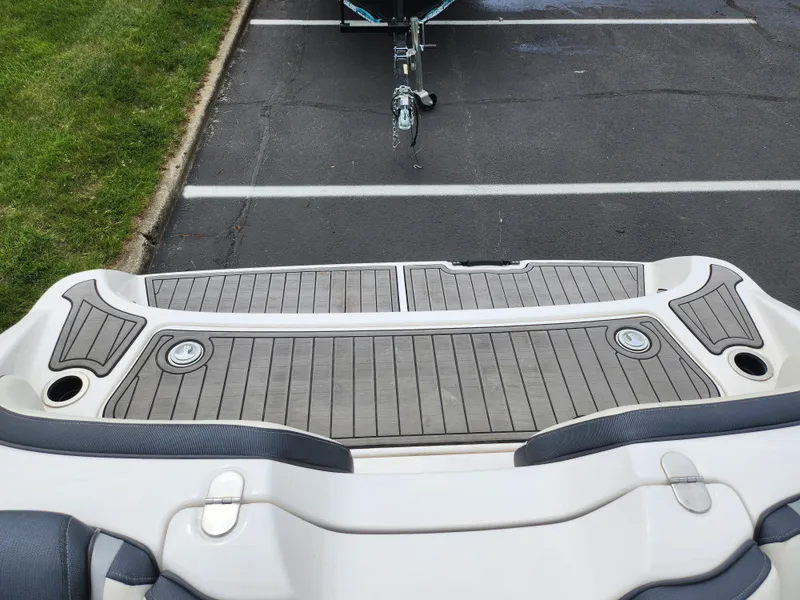 Slide: The Image of 2017 Yamaha Boats SX195 swim platform with teak-style decking in a parking lot. - 24