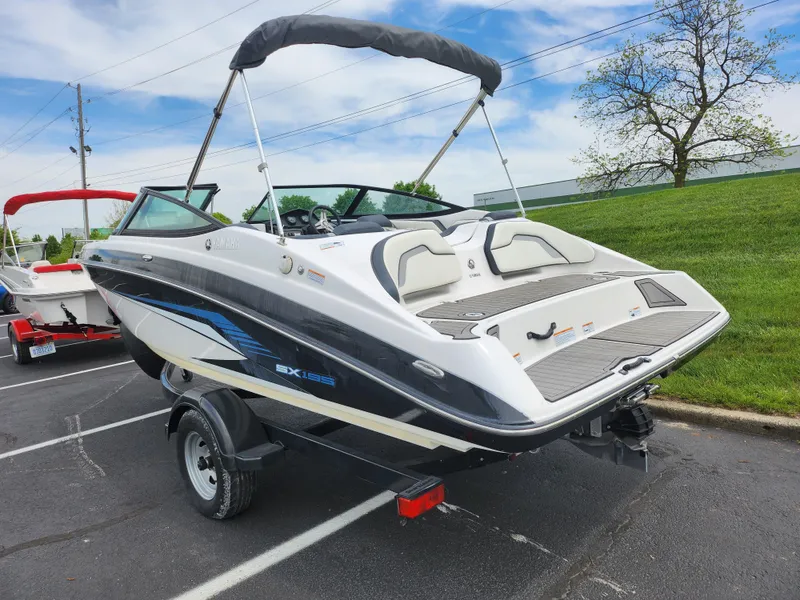 Slide: The Image of 2017 Yamaha Boats SX195 on trailer, parked outdoors with a bimini top. - 3