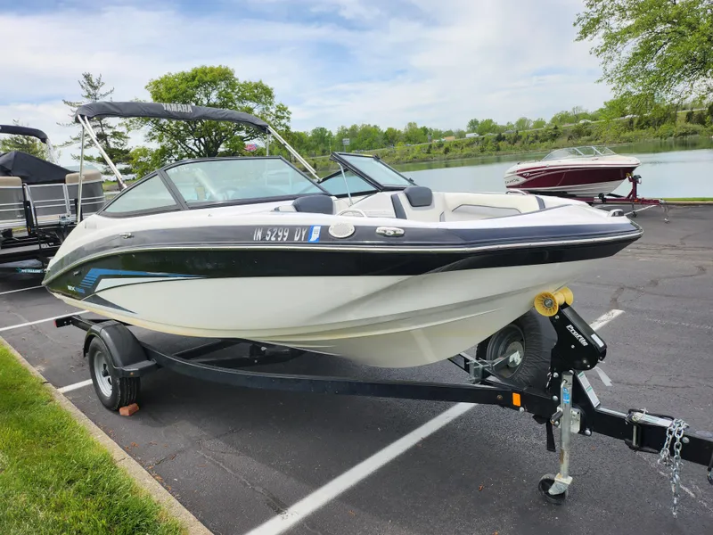 Slide: The Image of 2017 Yamaha Boats SX195 on trailer by a lakeside parking area. - 9