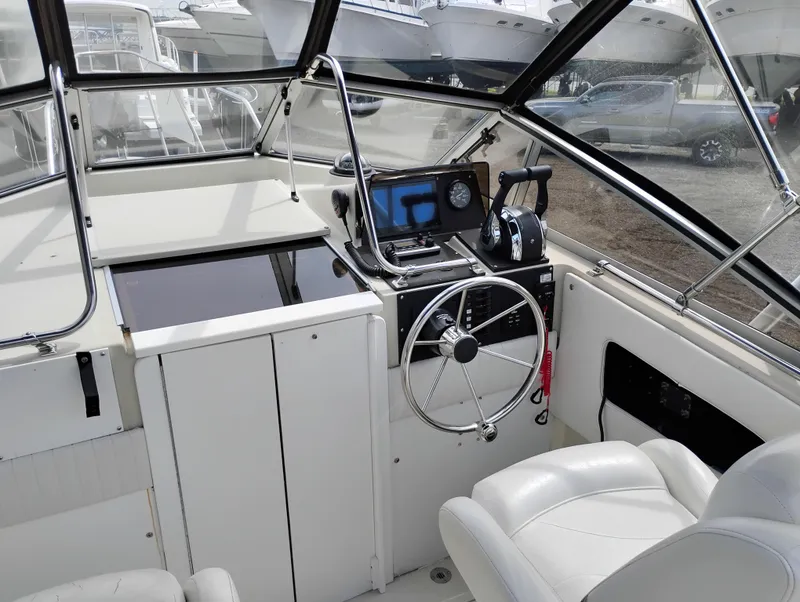 Slide: The Image of 1989 Boston Whaler 22 Renegade Cabin interior with steering wheel and control panel. - 11