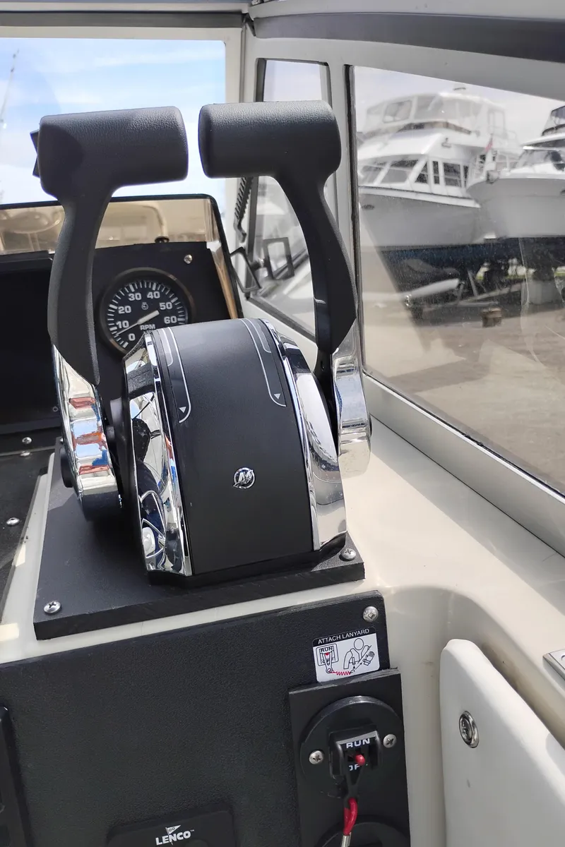 Slide: The Image of 1989 Boston Whaler 22 Renegade Cabin boat controls with dual throttle levers. - 12