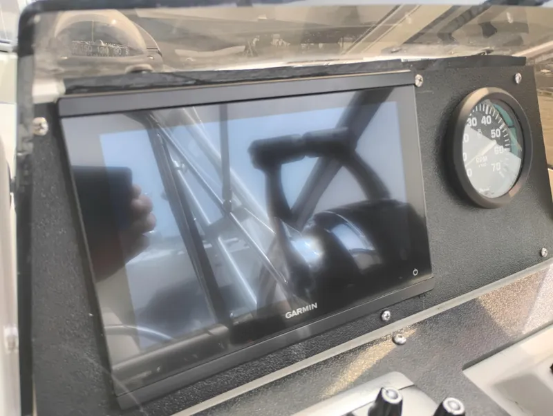 Slide: The Image of 1989 Boston Whaler 22 Renegade Cabin dashboard with Garmin display and gauge. - 14