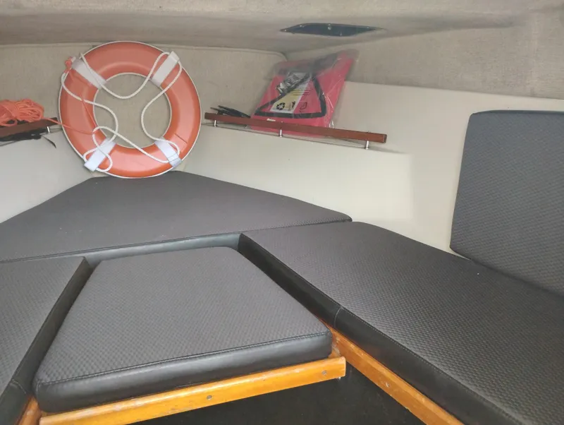Slide: The Image of 1989 Boston Whaler 22 Renegade Cabin interior with life preserver and cushions. - 17