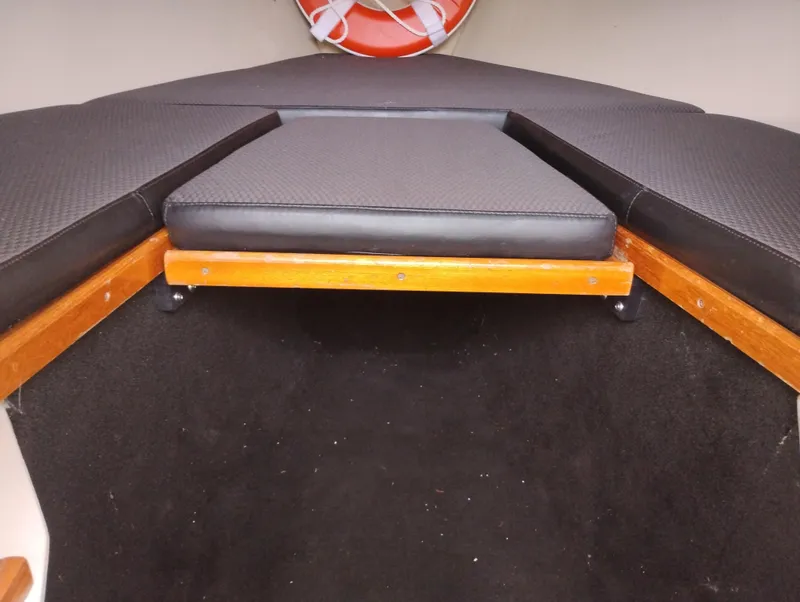 Slide: The Image of 1989 Boston Whaler 22 Renegade Cabin interior with cushioned seating and life preserver. - 18