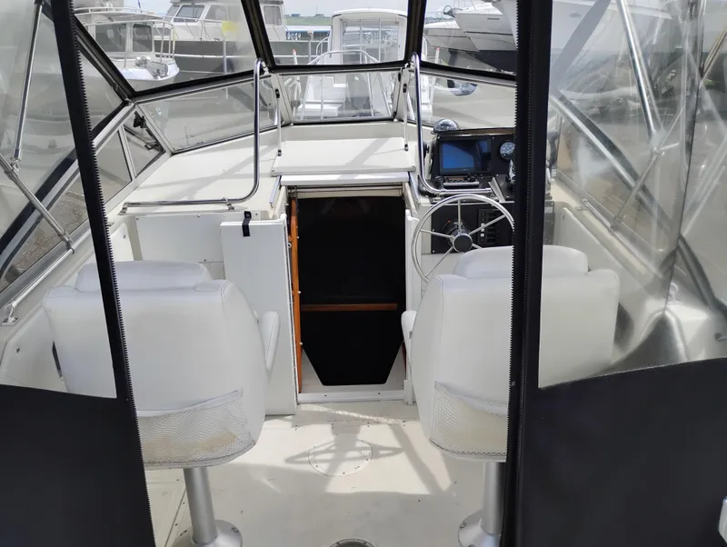 Slide: The Image of 1989 Boston Whaler 22 Renegade Cabin interior with helm, seats, and cabin entrance. - 21