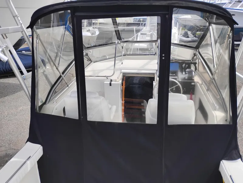 Slide: The Image of 1989 Boston Whaler 22 Renegade Cabin with enclosed cockpit and steering wheel visible. - 22