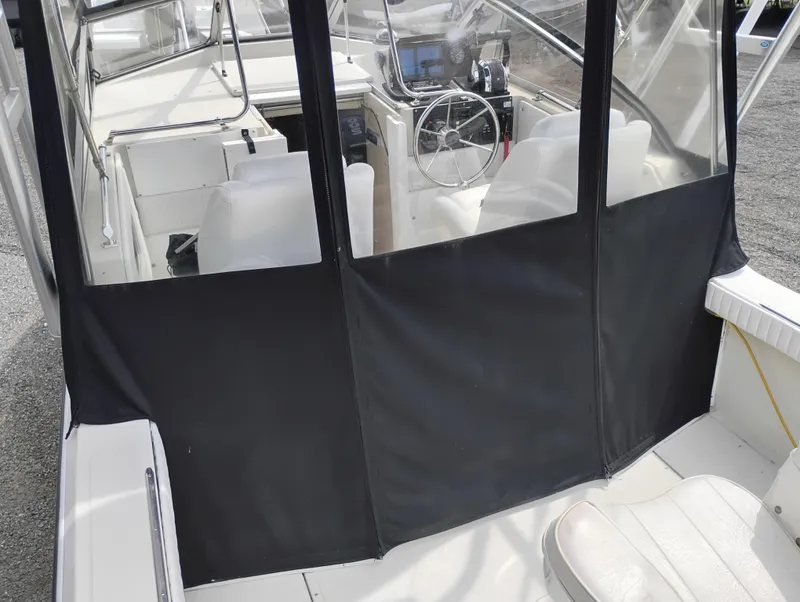 Slide: The Image of 1989 Boston Whaler 22 Renegade Cabin interior with steering wheel and seating. - 23