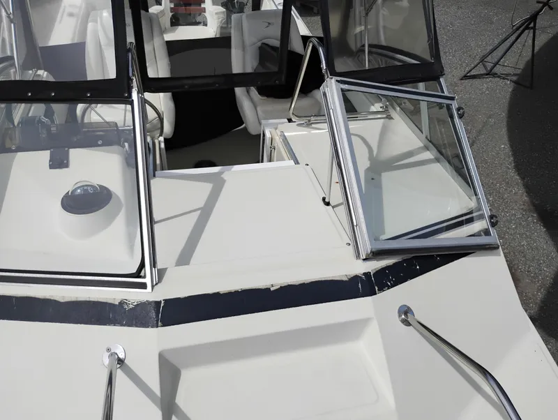 Slide: The Image of 1989 Boston Whaler 22 Renegade Cabin boat with open windshield and seating area. - 31