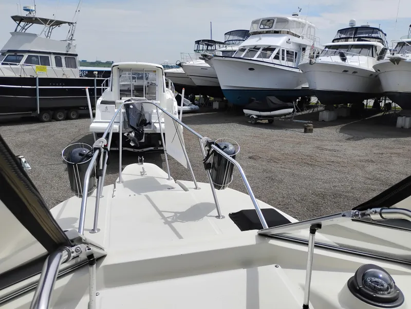 Slide: The Image of 1989 Boston Whaler 22 Renegade Cabin in a boatyard with other vessels. - 32
