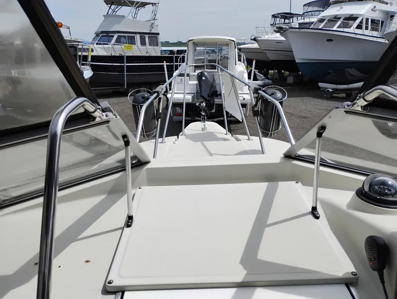 Slide: The Image of 1989 Boston Whaler 22 Renegade Cabin boat, docked among other vessels. - 33