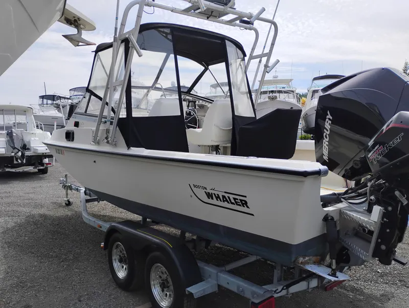 Slide: The Image of 1989 Boston Whaler 22 Renegade Cabin boat on trailer, featuring a Mercury outboard motor. - 4