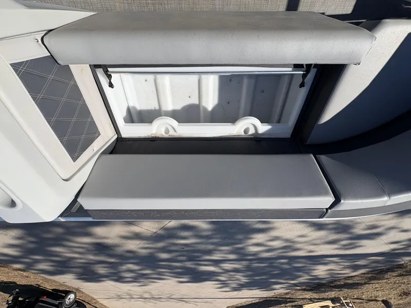 Slide: The Image of 2025 Custom Pontoon 160 Cruise storage compartment with cushioned seating and sleek design. - 6