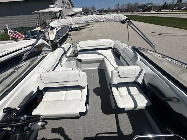 Slide: The Image of 2018 Formula 270 Bowrider with spacious white seating and canopy, docked outdoors. - 2