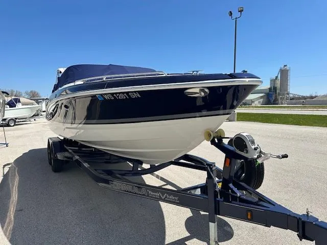 Slide: The Image of 2018 Formula 270 Bowrider boat on trailer, parked outdoors under clear blue sky. - 7