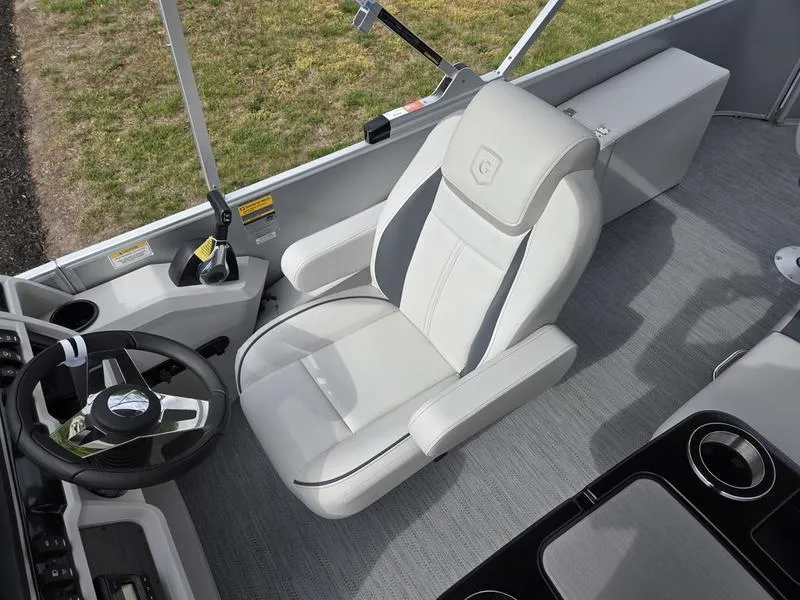 Slide: The Image of 2025 Godfrey Sweetwater 2286 FS boat interior with modern captain's chair and steering wheel. - 12