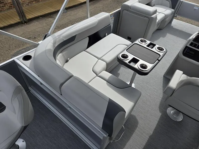 Slide: The Image of 2025 Godfrey Sweetwater 2286 FS boat interior with gray seating and cupholder table. - 18