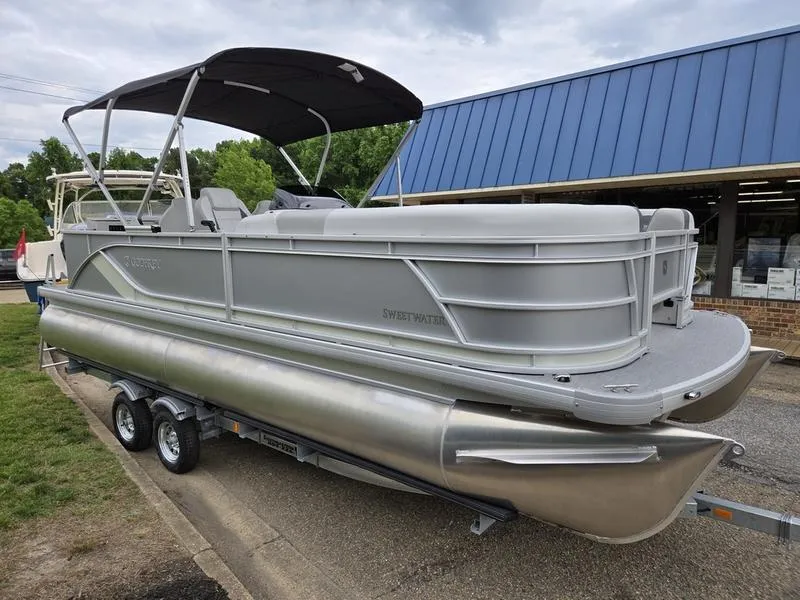 Slide: The Image of 2025 Godfrey Sweetwater 2286 FS pontoon boat with canopy, parked on a trailer. - 3