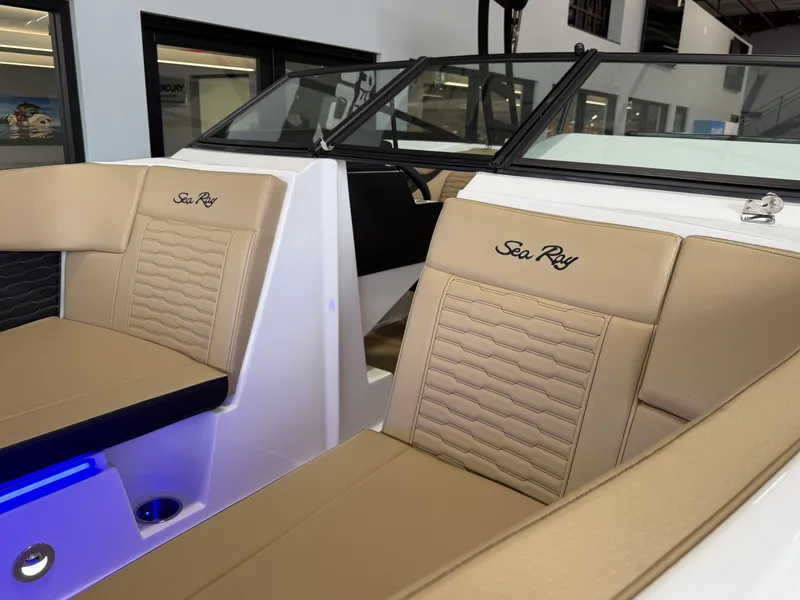 Slide: The Image of 2025 Sea Ray SPX230 boat interior with beige seating and embroidered logo. - 10