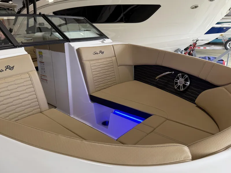 Slide: The Image of 2025 Sea Ray SPX230 boat interior with tan seating and blue LED lighting. - 11