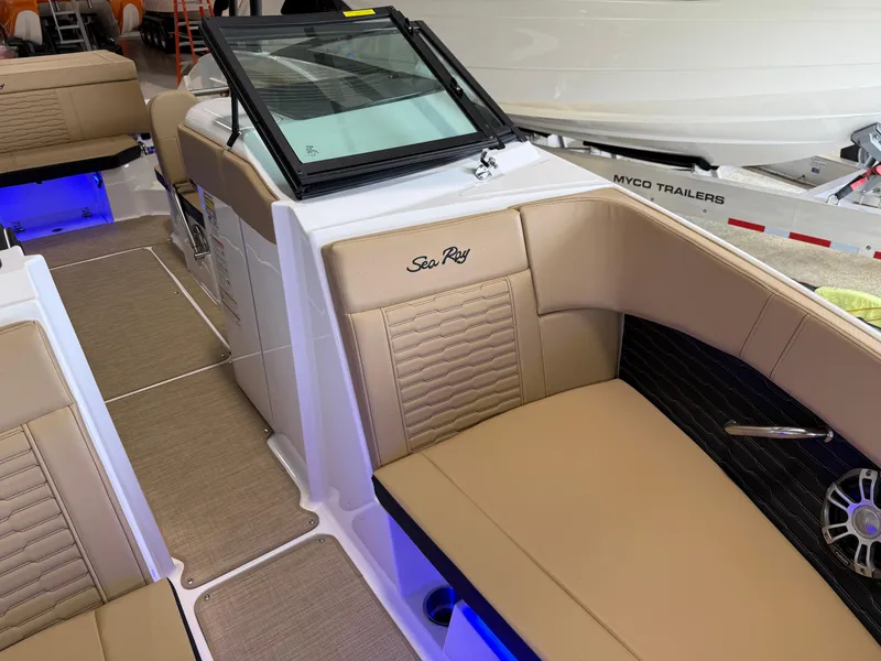 Slide: The Image of 2025 Sea Ray SPX230 boat interior with tan seating and blue LED lighting. - 12