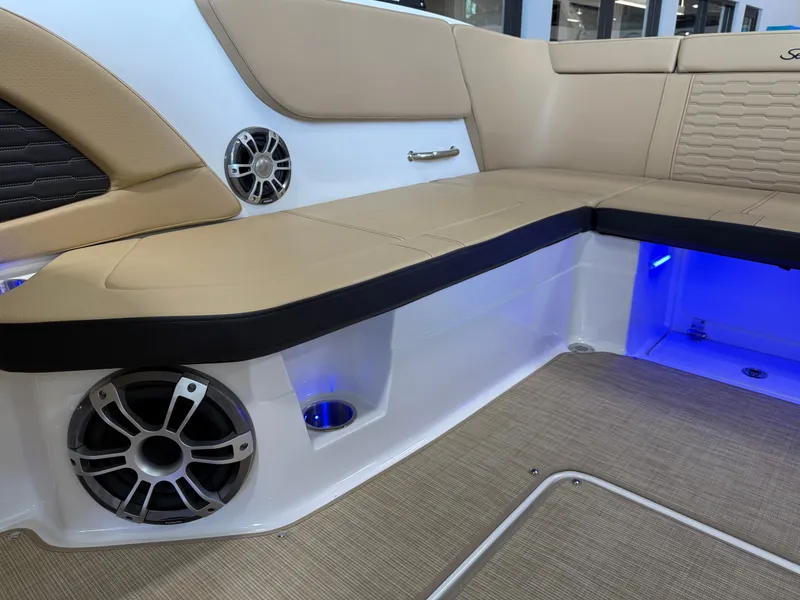 Slide: The Image of Luxurious interior of 2025 Sea Ray SPX230 boat with beige seating and blue LED lighting. - 15
