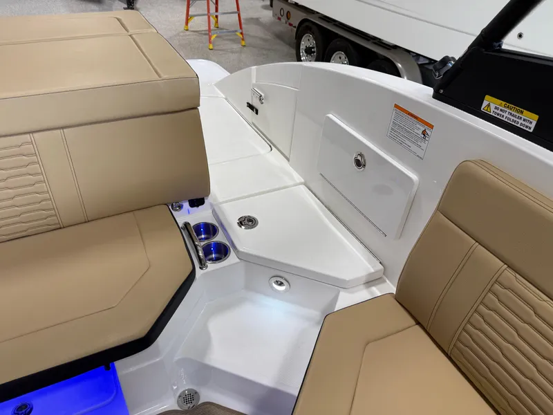 Slide: The Image of 2025 Sea Ray SPX230 boat interior with beige seating and cup holders. - 17