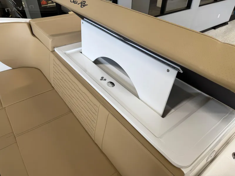 Slide: The Image of 2025 Sea Ray SPX230 boat interior with tan seating and storage compartment. - 26