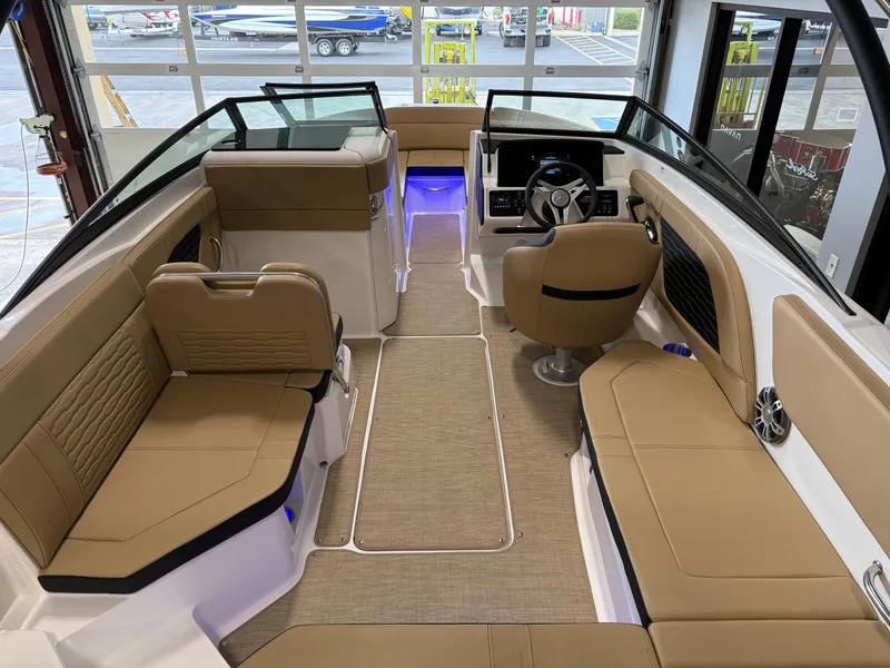 Slide: The Image of 2025 Sea Ray SPX230 boat interior with tan seating and modern dashboard. - 27